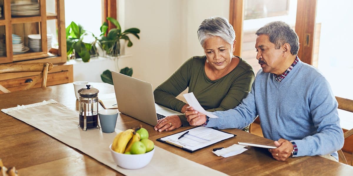 senior man and woman sitting at table having a discussion 