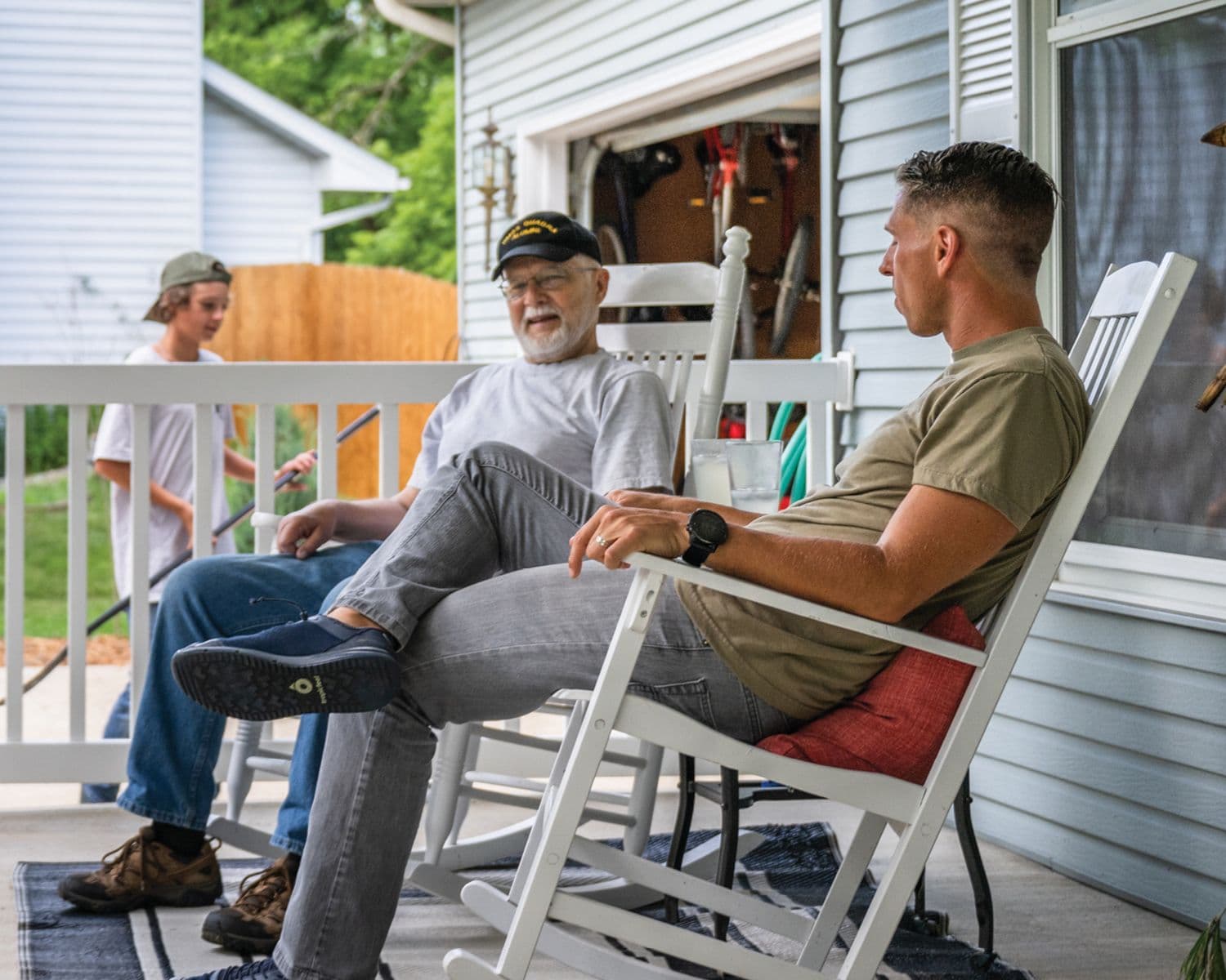 older father and son sitting on the porch