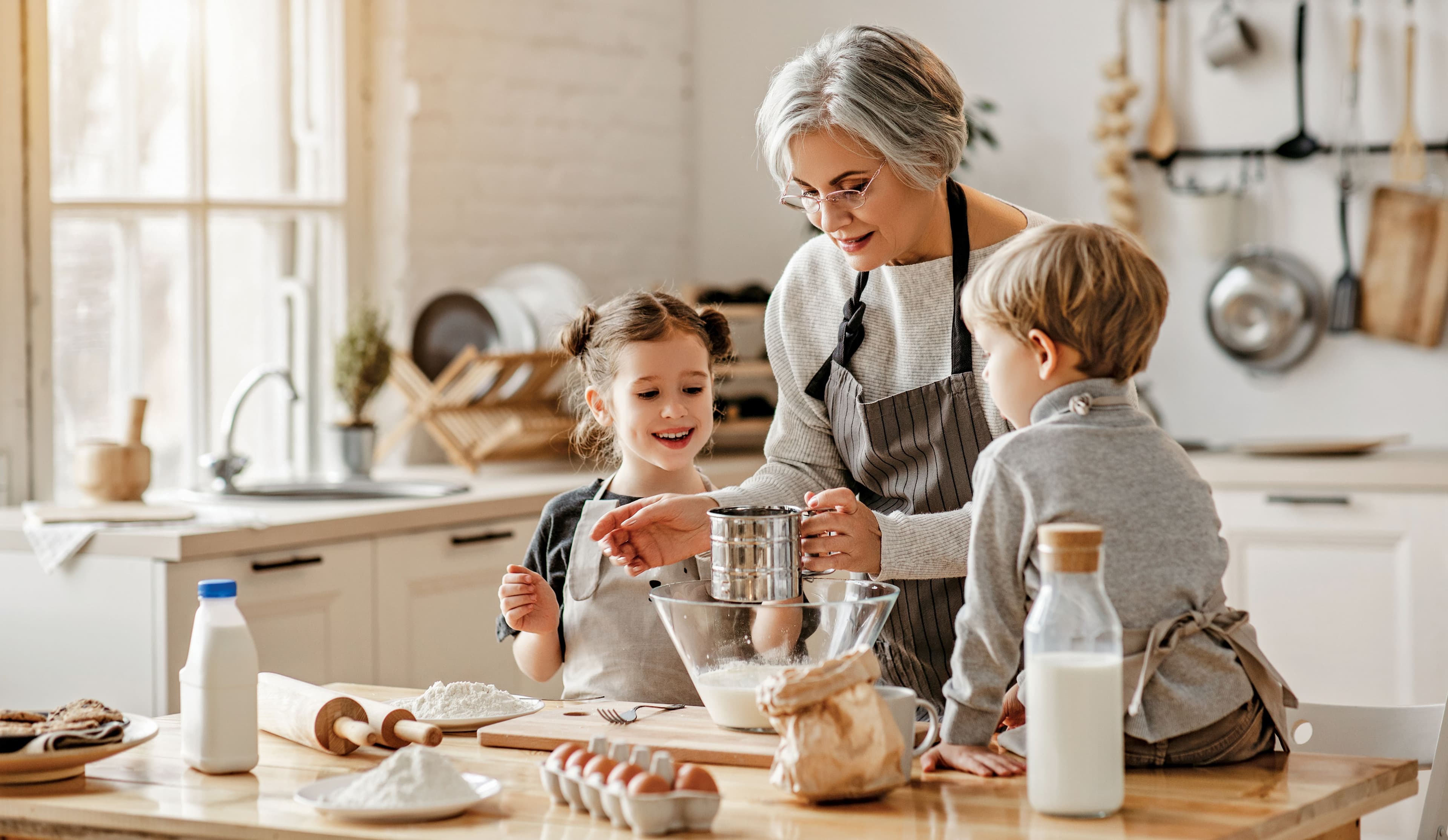 happy family grandmother and grandchildren cook in the kitchen, knead dough, bake cookies