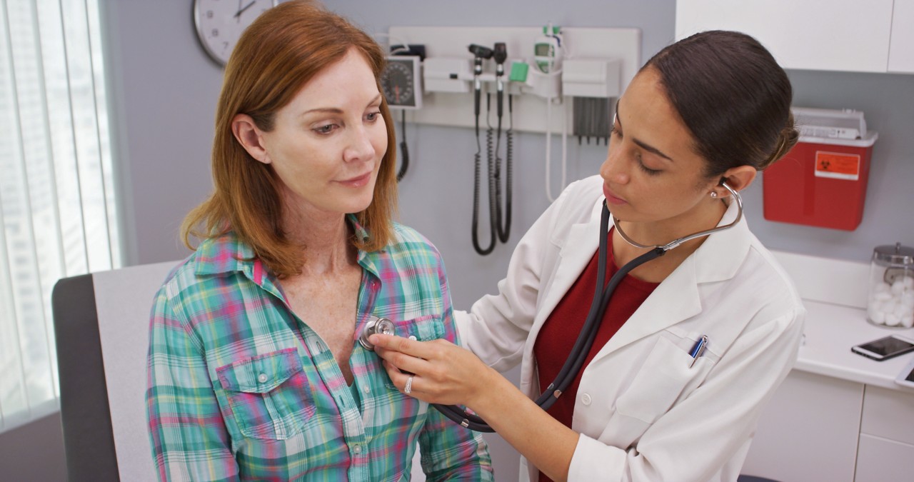 Doctor using stethoscope to examine senior members vitals