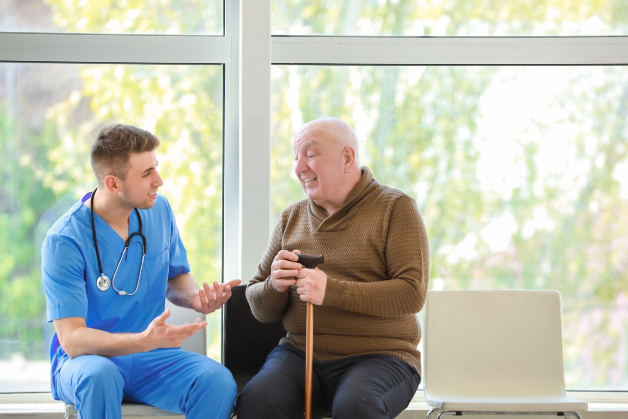 Medical worker with senior man in nursing home